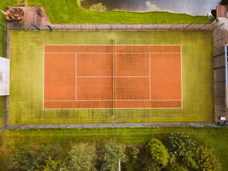 Drone captures aerial view of an empty tennis court in Aespa, Estonia.