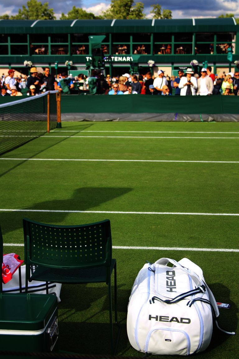 Vibrant tennis court scene with spectators, equipment, and a lively atmosphere during a match.