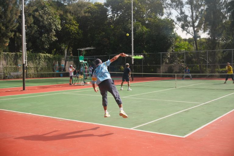 Dynamic tennis match on an outdoor court with players in motion, showcasing athleticism and teamwork.