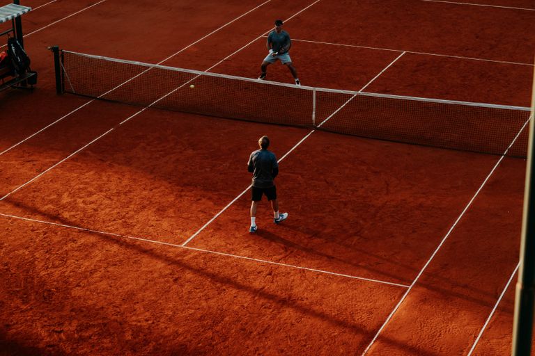 Intense tennis match on a vibrant clay court, capturing the competitive spirit.
