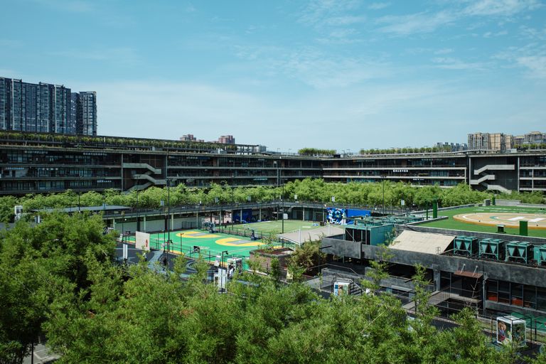 Aerial view of a modern multi-level structure surrounded by greenery in Chengdu, China.